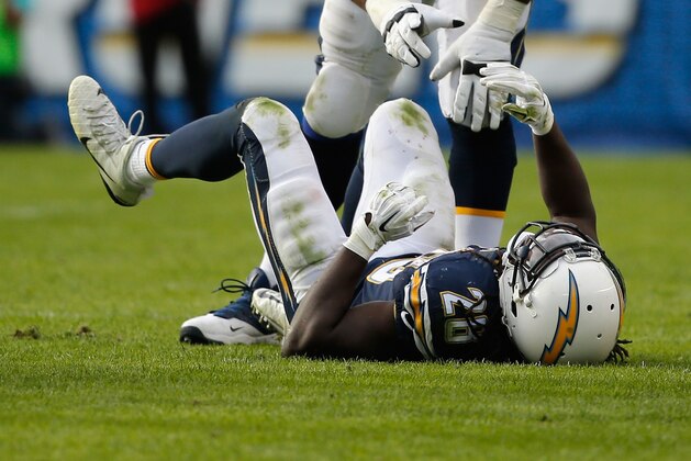 SAN DIEGO, CA - DECEMBER 20:   Orlando Franklin #74 of the San Diego Chargers reaches out to  Melvin Gordon #28 of the San Diego Chargers after he was injured during the first half of a game against the Miami Dolphins at Qualcomm Stadium on December 20, 2015 in San Diego, California.  (Photo by Sean M. Haffey/Getty Images)