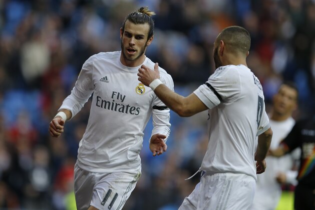 Real Madrid's Gareth Bale celebrates with teammate Karim Benzema, right, after scoring their side's fourth goal against Rayo Vallecano during the Spanish La Liga soccer match between Real Madrid and Rayo Vallecano at the Santiago Bernabeu stadium in Madrid, Sunday, Dec. 20, 2015. Bale scored four goals and Benzema three in Real Madrid's 10-2 victory. (AP Photo/Francisco Seco)