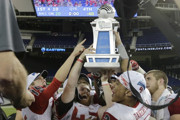 Western Kentucky wide receiver Jared Dangerfield (21) and long snapper Nolan Dowling (47) hold up the trophy after Kentucky defeated South Florida 45-35 in the second half of the NCAA college football Miami Beach Bowl game, Monday, Dec. 21, 2015, in Miami. (AP Photo/Lynne Sladky)