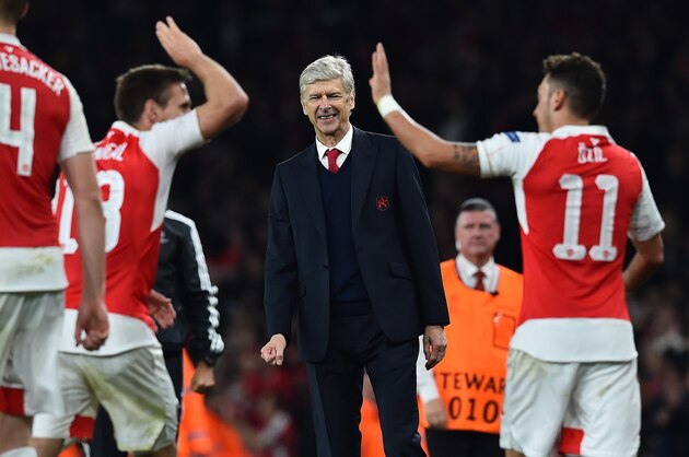 Arsenal's French manager Arsene Wenger (C) watches as Arsenal's German midfielder Mesut Ozil (R) celebrates scoring his team's second goal with teamamte Arsenal's Spanish defender Nacho Monreal during the UEFA Champions League football match between Arsenal and Bayern Munich at the Emirates Stadium in London, on October 20, 2015.  Arsenal won the match 2-0.  AFP PHOTO / BEN STANSALL        (Photo credit should read BEN STANSALL/AFP/Getty Images)
