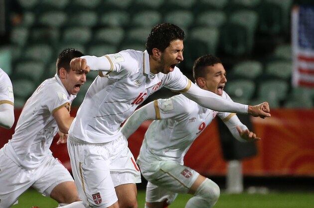 Marko Grujic of Serbia (2nd R) leads teammates as they celebrate their victory during a penalty shootout during the FIFA U20 World Cup quarter-final match between the USA and Serbia in Auckland on June 14, 2015.     AFP PHOTO / Fiona GOODALL        (Photo credit should read Fiona GOODALL/AFP/Getty Images)