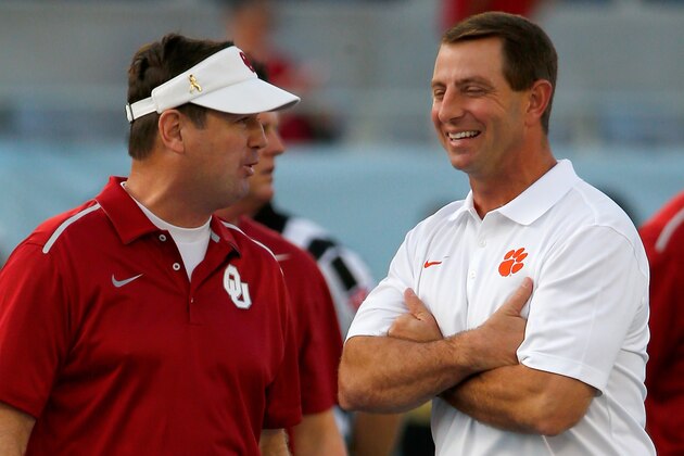 ORLANDO, FL - DECEMBER 29:  Head coach Bob Stoops of the Oklahoma Sooners (L) and head coach Dabo Swinney of the Clemson Tigers speak before the Russell Athletic Bowl at Florida Citrus Bowl on December 29, 2014 in Orlando, Florida.  (Photo by Sam Greenwood/Getty Images)