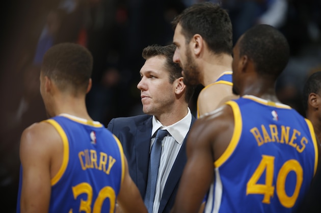 Golden State Warriors interim head coach Luke Walton, center, confers with players during a time out against the Denver Nuggets in the second half of an NBA basketball game Sunday, Nov. 22, 2015, in Denver. Golden State won 118-105. (AP Photo/David Zalubowski)
