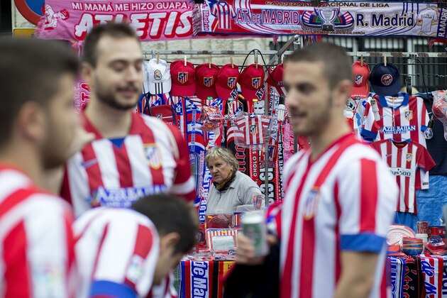 MADRID, SPAIN - OCTOBER 04:  Atletico de Madrid fans speaks ahead a merchandaising stall before the La Liga match between Club Atletico de Madrid and Real Madrid CF at Vicente Calderon Stadium outdoors on October 4, 2015 in Madrid, Spain.  (Photo by Gonzalo Arroyo Moreno/Getty Images)
