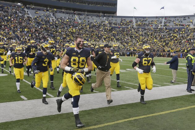 Michigan head coach Jim Harbaugh leads the Michigan team to the locker room before the first half of an NCAA college football game against Ohio State, Saturday, Nov. 28, 2015, in Ann Arbor, Mich. (AP Photo/Carlos Osorio)
