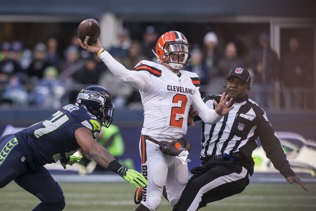 SEATTLE, WA - DECEMBER 20: Quarterback Johnny Manziel #2 of the Cleveland Browns passes the ball as he runs into umpire Barry Anderson, right, while linebacker Bobby Wagner #54 of the Seattle Seahawks puts on the pressure during the second half of a football game at CenturyLink Field on December 20, 2015 in Seattle, Washington. The Seahawks won the game 30-13. (Photo by Stephen Brashear/Getty Images)