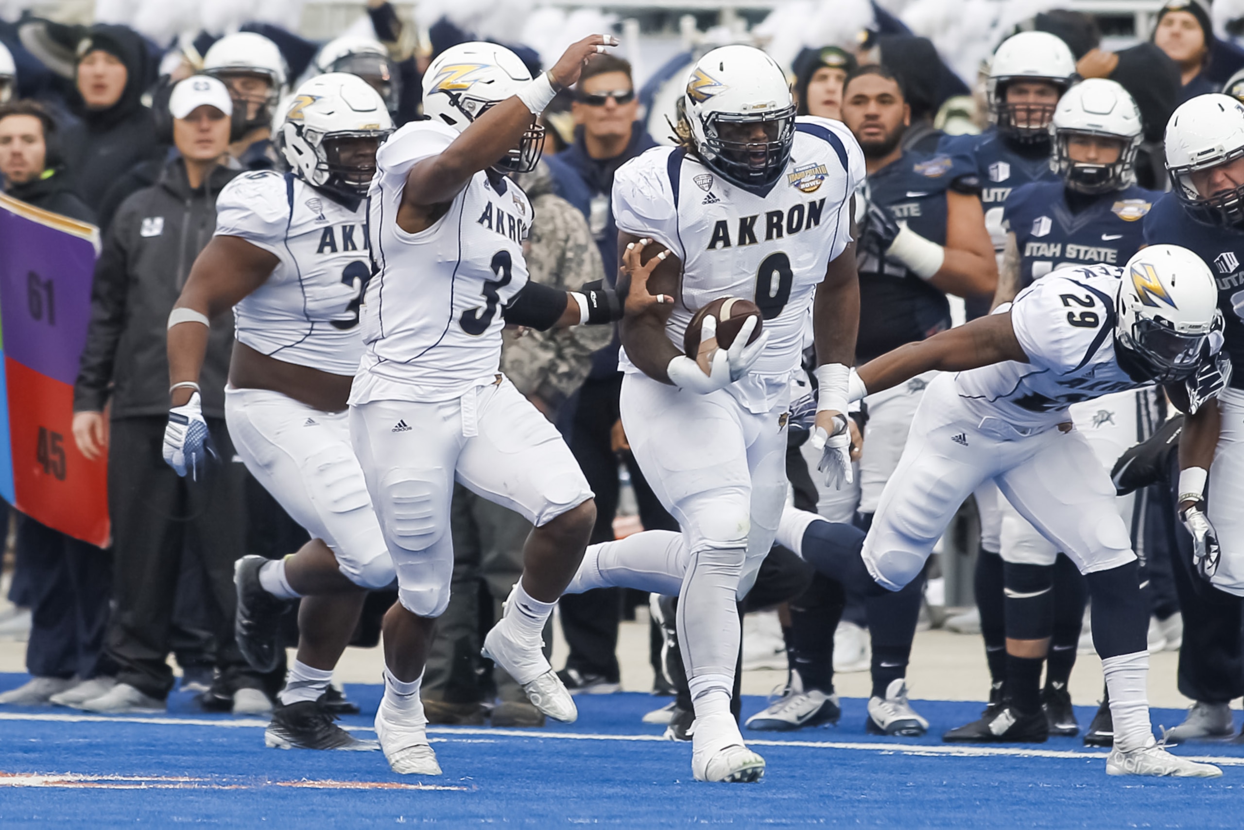 Akron defensive linesman Rodney Coe (9) runs a recovered Utah State fumble 56 yards during the first half of the Potato Bowl NCAA college football game in Boise, Idaho, on Tuesday, Dec. 22, 2015. (AP Photo/Otto Kitsinger)