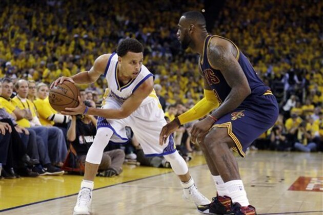 Golden State Warriors guard Stephen Curry, left, is guarded by Cleveland Cavaliers forward LeBron James during the second half of Game 5 of basketball's NBA Finals in Oakland, Calif., Sunday, June 14, 2015. (AP Photo/Ben Margot)