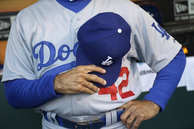 Los Angeles Dodgers first base coach Davey Lopes wears Jackie Robinson's No. 42 as he observes a moment of silence for the victims of the Boston marathon bombings, before the Dodgers' baseball game against the San Francisco Giants on Tuesday, April 15, 2014, in San Francisco. (AP Photo/Marcio Jose Sanchez)