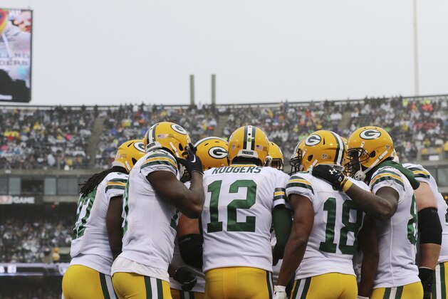 Green Bay Packers quarterback Aaron Rodgers huddles with this team in action against the Oakland Raiders during an NFL football game Sunday, Dec. 20, 2015, in Oakland, Calif. (AP Photo/Ryan Kang)
