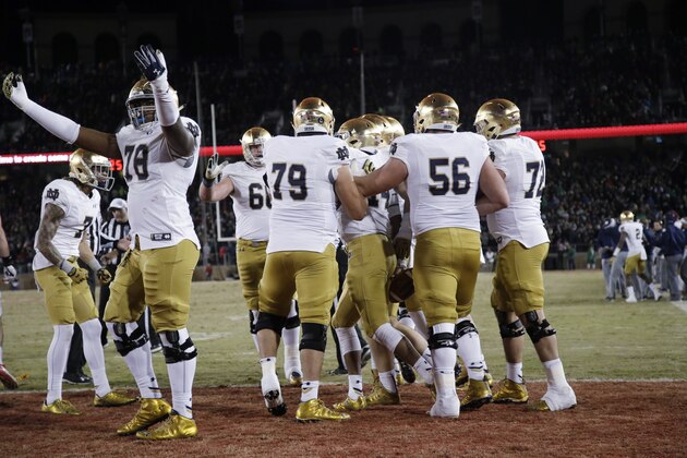 Notre Dame quarterback DeShone Kizer, center, is mobbed by teammates after scoring on a 2-yard run against Stanford late in the fourth quarter of an NCAA college football game Saturday, Nov. 28, 2015, in Stanford, Calif. Stanford won 38-36. (AP Photo/Marcio Jose Sanchez)