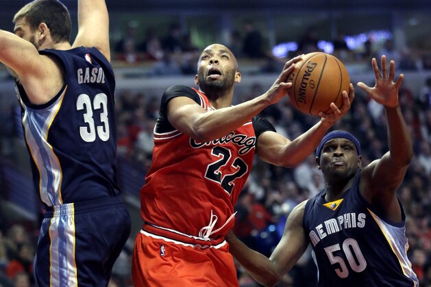 Chicago Bulls forward Taj Gibson, center, shoots between Memphis Grizzlies center Marc Gasol, left, and forward Zach Randolph during the second half of an NBA basketball game on Wednesday, Dec. 16, 2015, in Chicago. The Bulls won 98-85. (AP Photo/Nam Y. Huh)