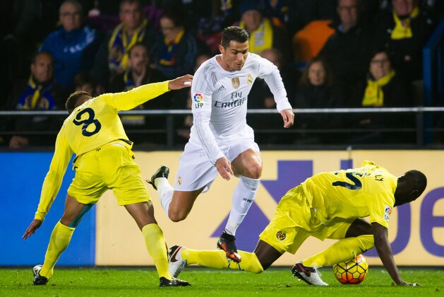 VILLARREAL, SPAIN - DECEMBER 13: Cristiano Ronaldo of Real Madrid CF conducts the ball between Jonathan Dos Santos (L) and Eric Bailly (R) of Villarreal CF during the La Liga match between Villarreal CF and Real Madrid CF at El Madrigal on December 13, 2015 in Villarreal, Spain. (Photo by Alex Caparros/Getty Images)