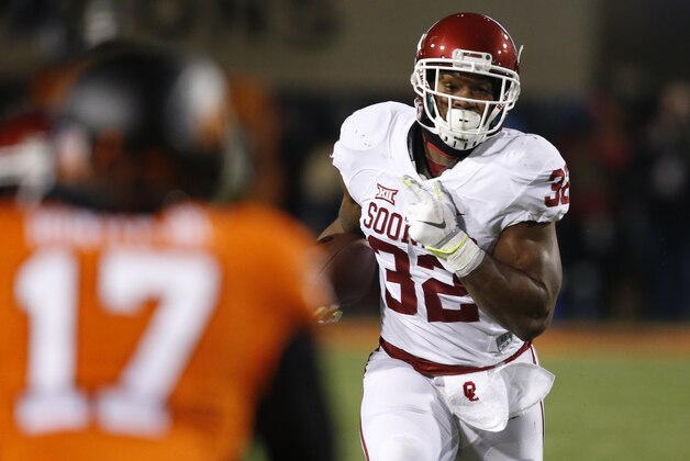 Oklahoma running back Samaje Perine (32) carries against Oklahoma State cornerback Michael Hunter (17) in the second quarter of an NCAA college football game in Stillwater, Okla., Saturday, Nov. 28, 2015. (AP Photo/Sue Ogrocki)