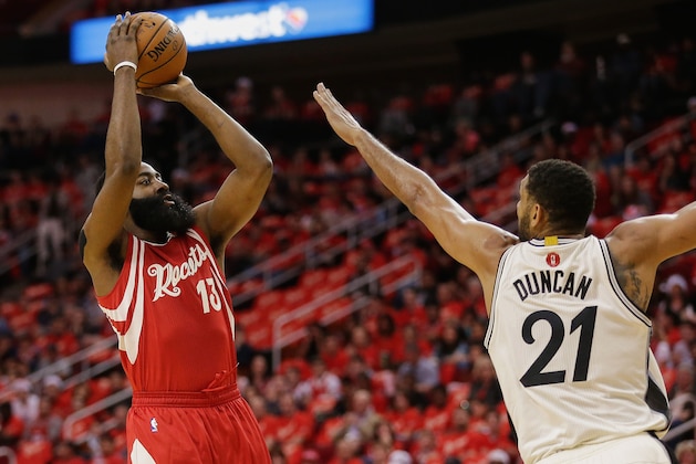 Houston Rockets guard James Harden (13) shoots over the outstretched arm of San Antonio Spurs center Tim Duncan (21) in the first half of an NBA basketball game Friday, Dec. 25, 2015, in Houston. (AP Photo/Bob Levey)