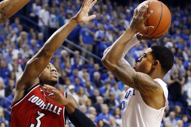 Kentucky's Tyler Ulis, right, shoots while defended by Louisville's Trey Lewis during the first half of an NCAA college basketball game, Saturday, Dec. 26, 2015, in Lexington, Ky. (AP Photo/James Crisp)