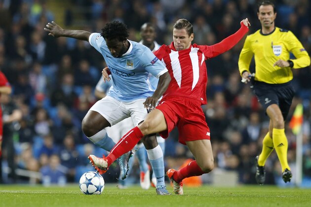 Manchester City's Wilfried Bony, left, and Sevilla's Grzegorz Krychowiak fight for the ball during the Champions League Group D soccer match between Manchester City and Sevilla at the Etihad Stadium in Manchester, England, Wednesday, Oct. 21, 2015. (AP Photo/Jon Super)