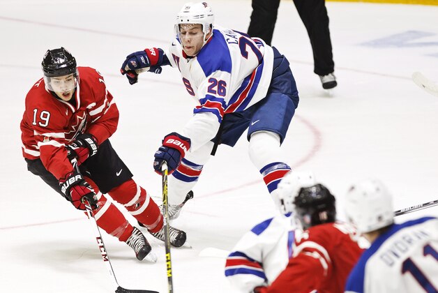 Canada's Brayden Point, left, and USA's Brandon Carlo fight for the puck during the 2016 IIHF World Junior Ice Hockey Championship match between USA and Canada in Helsinki, Finland Saturday, Dec. 26, 2015. (Roni Rekomaa/Lehtikuva via AP)  FINLAND OUT