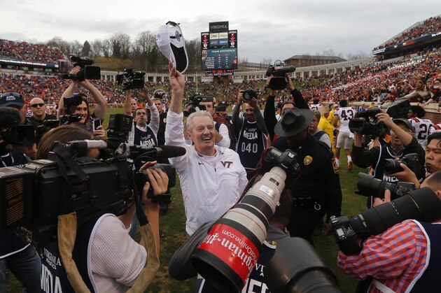 Virginia Tech head coach Frank Beamer is surrounded by media as he celebrates  defeating Virginia 23-20 an NCAA college football game in Charlottesville, Va., Saturday, Nov. 28, 2015.  (AP Photo/Steve Helber)