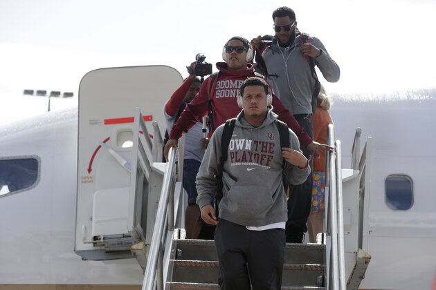 Oklahoma football players disembark from their plane, Saturday, Dec. 26, 2015, in Miami. Oklahoma plays Clemson in the Orange Bowl NCAA college playoff semifinal Dec. 31 in Miami. (AP Photo/Lynne Sladky) Oklahoma football players disembark from their plane, Saturday, Dec. 26, 2015, in Miami. Oklahoma plays Clemson in the Orange Bowl NCAA college playoff semifinal Dec. 31 in Miami. (AP Photo/Lynne Sladky)