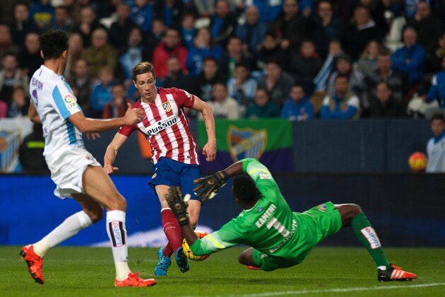 Atletico Madrid's forward Fernando Torres (C) shoots against Malaga's Cameroonian goalkeeper Carlos Kameni during the Spanish league football match Malaga CF vs Club Atletico de Madrid at La Rosaleda stadium in Malaga on December 20, 2015.   AFP PHOTO / JORGE GUERRERO / AFP / Jorge Guerrero        (Photo credit should read JORGE GUERRERO/AFP/Getty Images)