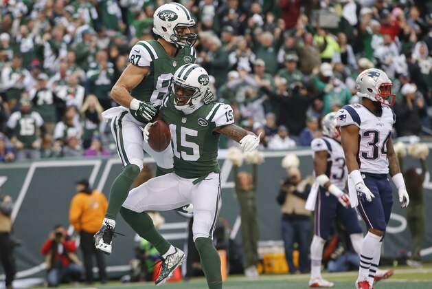New York Jets wide receiver Brandon Marshall (15) and Eric Decker (87) celebrate a touchdown as New England Patriots' Leonard Johnson (34) looks on during the first half of an NFL football game, Sunday, Dec. 27, 2015, in East Rutherford, N.J. (AP Photo/Kathy Willens)