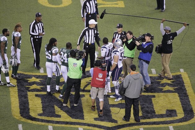 The officials meet New York Jets' Darrelle Revis (24), teammate Calvin Pryor (25) and New England Patriots' Matthew Slater (18) and teammate Rob Ninkovich (50) for the coin toss before the overtime period of an NFL football game between the New York Jets and the New England Patriots, Sunday, Dec. 27, 2015, in East Rutherford, N.J. The Jets won 26-20. (AP Photo/Peter Morgan)