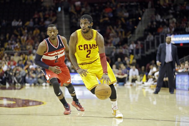 Cleveland Cavaliers' Kyrie Irving, right, drives past Washington Wizards' John Wall in an NBA basketball game Wednesday, Nov. 20, 2013, in Cleveland. (AP Photo/Mark Duncan)