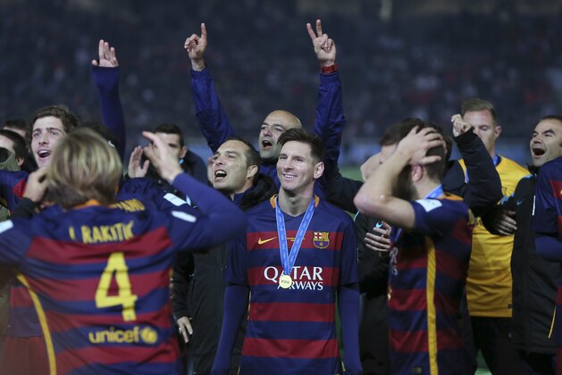 FC Barcelona’s Lionel Messi, center, stands with his medal with his team mates as they celebrate winning the final match against River Plate at the FIFA Club World Cup soccer tournament in Yokohama, near Tokyo, Sunday, Dec. 20, 2015. FC Barcelona beat River Plate 3-0. (AP Photo/Eugene Hoshiko)