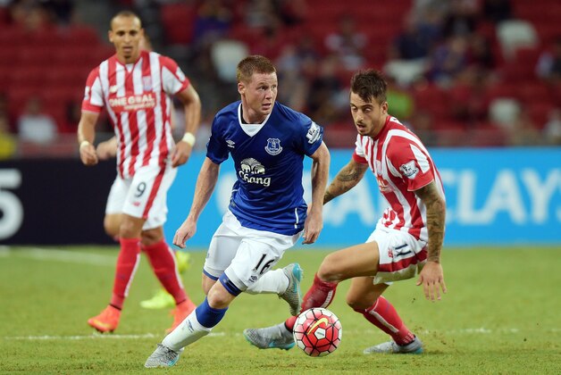 Everton's James McCarthy, center, dribbles past Stoke City's Joselu, right, in their soccer match for the Barclays Asia Trophy in Singapore, Wednesday, July 15, 2015. (AP Photo/Joseph Nair)
