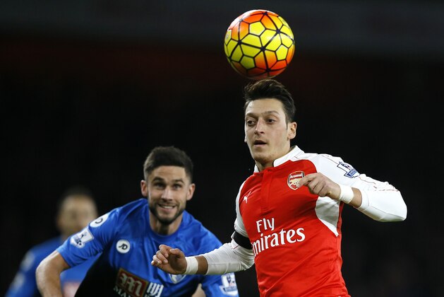 Arsenal's Mesut Ozil, right, vies for the ball with Bournemouth's Andrew Surman during the English Premier League soccer match between Arsenal and Bournemouth at Emirates stadium in London, Monday, Dec. 28, 2015. (AP Photo/Kirsty Wigglesworth)