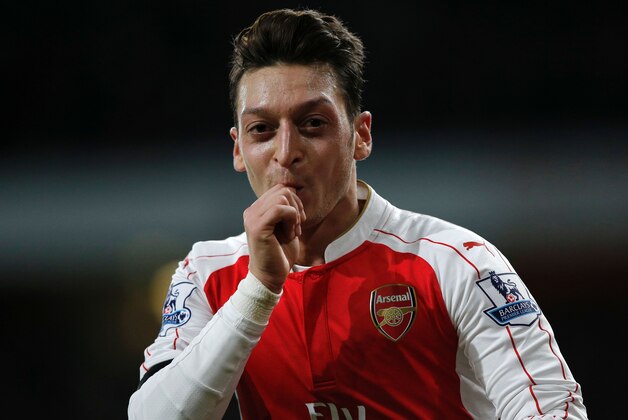 Arsenal's German midfielder Mesut Ozil celebrates after scoring their second goal during the English Premier League football match between Arsenal and Bournemouth at the Emirates Stadium in London on December 28, 2015. AFP PHOTO / ADRIAN DENNIS

RESTRICTED TO EDITORIAL USE. No use with unauthorized audio, video, data, fixture lists, club/league logos or 'live' services. Online in-match use limited to 75 images, no video emulation. No use in betting, games or single club/league/player publications. / AFP / ADRIAN DENNIS        (Photo credit should read ADRIAN DENNIS/AFP/Getty Images)