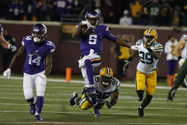 Minnesota Vikings quarterback Teddy Bridgewater (5) evades Green Bay Packers defensive end Datone Jones (95) during the second half of an NFL football game in Minneapolis, Sunday, Nov. 22, 2015. (AP Photo/Jim Mone)