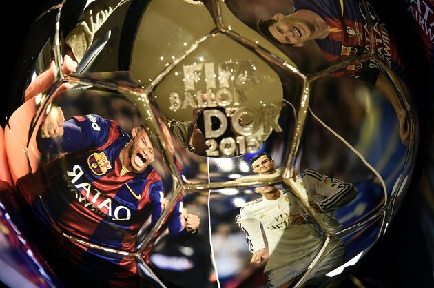 TOPSHOT - A picture taken on December 15, 2015 shows (From L) images of Barcelona's Brazilian forward Neymar, Real Madrid's Portuguese forward Cristiano Ronaldo and  Barcelona's Argentinian forward Lionel Messi, reflecting into the Ballon d'Or 2015 trophy displayed at the Mellerio jewelery workshops in Paris.
The Ballon d'Or 2015, Fifa's annual football award given to the male player considered to have performed the best in the previous calendar year, will be awarded on January 11, 2016 during a gala event in Zurich. / AFP / FRANCK FIFE        (Photo credit should read FRANCK FIFE/AFP/Getty Images)