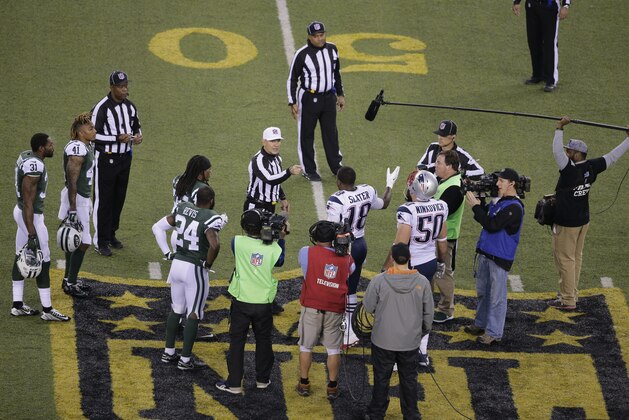 The officials meet New York Jets' Darrelle Revis (24), teammate Calvin Pryor (25) and New England Patriots' Matthew Slater (18) and teammate Rob Ninkovich (50) for the coin toss before the overtime period of an NFL football game between the New York Jets and the New England Patriots Sunday, Dec. 27, 2015, in East Rutherford, N.J. The Jets won 26-20. (AP Photo/Peter Morgan)