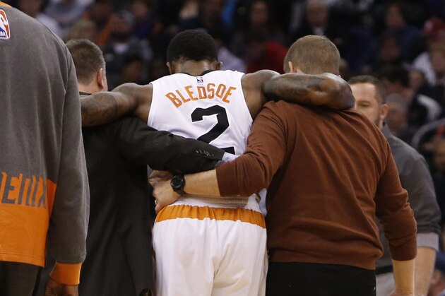 Phoenix Suns guard Eric Bledsoe (2) is helped off the court in the second quarter during an NBA basketball game against the Philadelphia 76ers, Saturday, Dec. 26, 2015, in Phoenix. (AP Photo/Rick Scuteri)