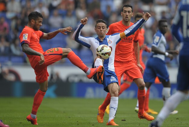 FC Barcelona's Dani Alvez, from Brazil, left, duels for the ball against Espanyol's Sergio Garcia, second left, during a Spanish La Liga soccer match at Cornella-El Prat stadium in Cornella Llobregat, Spain, Saturday, April 25, 2015. (AP Photo/Manu Fernandez)