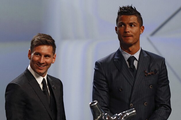 FC Barcelone Argentinian striker Lionel Messi (2ndR) shares a laugh with his Urugayan teammate Luis Suarez (2ndL) and Danish former football player and ceremony host Peter Schmeichel (L) eyed by Real Madrid's Portuguese striker Cristiano Ronaldo during the awarding ceremony for the Best Men's player in Europe at the end of the UEFA Champions League Group stage draw ceremony, on August 27, 2015 in Monaco. AFP PHOTO / VALERY HACHE        (Photo credit should read VALERY HACHE/AFP/Getty Images)