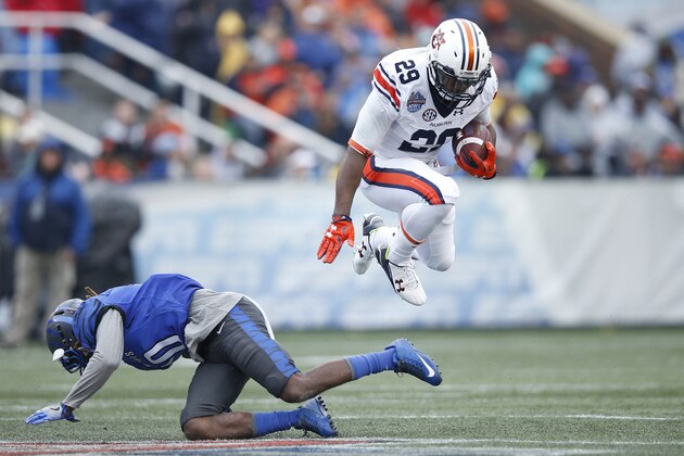 BIRMINGHAM, AL - DECEMBER 30: Jovon Robinson #29 of the Auburn Tigers jumps over a tackle attempt by Dontrell Nelson #10 of the Memphis Tigers in the first half of the Birmingham Bowl at Legion Field on December 30, 2015 in Birmingham, Alabama. (Photo by Joe Robbins/Getty Images)
