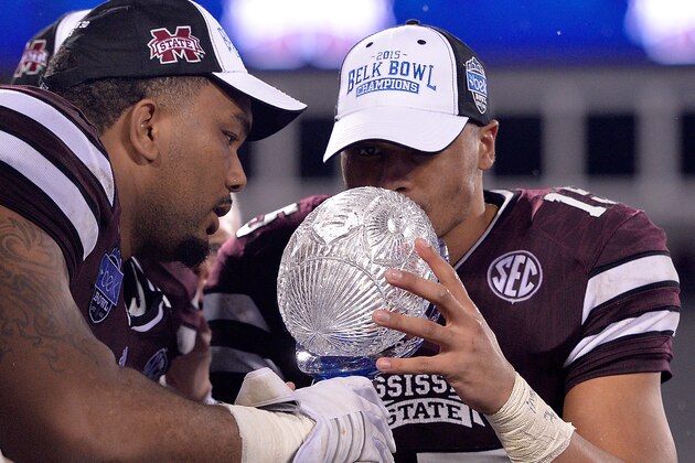 CHARLOTTE, NC - DECEMBER 30:  Dak Prescott #15 of the Mississippi State Bulldogs kisses the trophy after a win over the North Carolina State Wolfpack in  the Belk Bowl at Bank of America Stadium on December 30, 2015 in Charlotte, North Carolina. Mississippi State won 51-28.  (Photo by Grant Halverson/Getty Images)