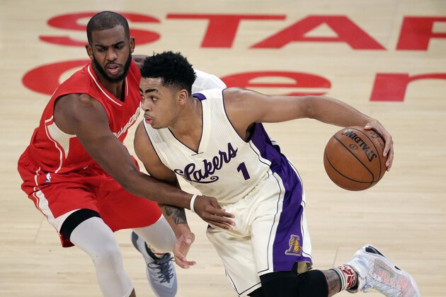 Los Angeles Lakers guard D'Angelo Russell, right, drives around Los Angeles Clippers guard Chris Paul during the first half of an NBA basketball game in Los Angeles, Friday, Dec. 25, 2015. (AP Photo/Chris Carlson)