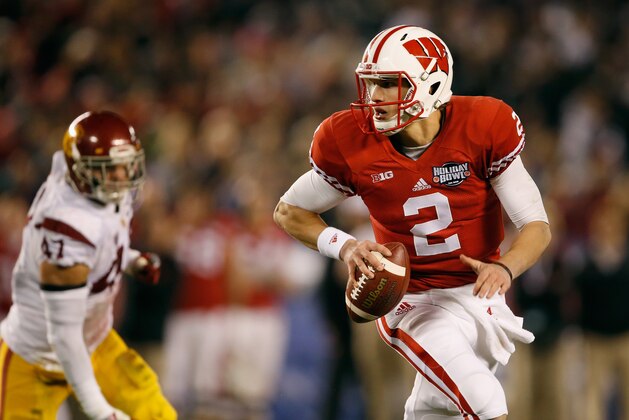 SAN DIEGO, CA - DECEMBER 30:  Joel Stave #2 of the Wisconsin Badgers eludes Scott Felix #47 of the USC Trojans during the second quarter of  the National University Holiday Bowl at Qualcomm Stadium on December 30, 2015 in San Diego, California.  (Photo by Sean M. Haffey/Getty Images)