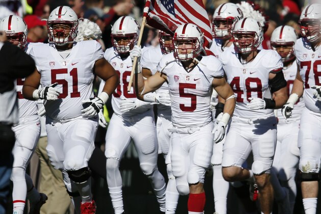 Stanford running back Christian McCaffrey carries an American flag on to the field as the team takes the gridiron to face Colorado  in the first half of an NCAA college football game Saturday, Nov. 7, 2015, in Boulder, Colo. (AP Photo/David Zalubowski)