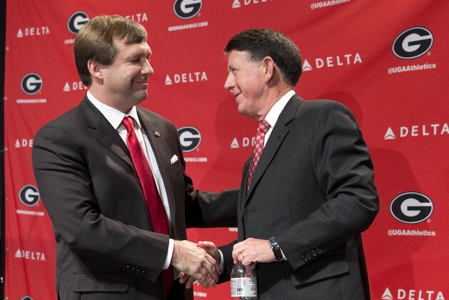 Alabama defensive coordinator Kirby Smart, left, speaks to Georgia athletic director Greg Mcgarity after during a press conference where he was introduced as Georgia's new head football coach  Monday, Dec. 7, 2015, in Athens, Ga. Smart will stay with the Crimson Tide through the NCAA college playoffs. (AP Photo/John Bazemore)