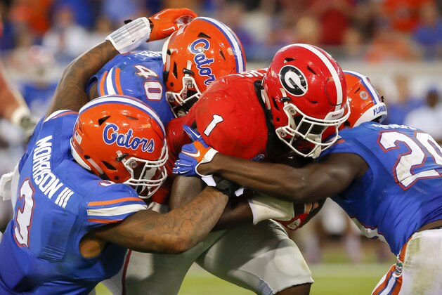 Florida linebacker Jarrad Davis (40) Florida defensive back Marcus Maye (20) and Florida linebacker Antonio Morrison III (3) gang tackle Georgia running back Sony Michel (1) during the second half of an NCAA college football game  Saturday, Oct. 31, 2015, in Jacksonville, Fla. Florida defeated Georgia 27-3. (AP Photo/Stephen B. Morton)