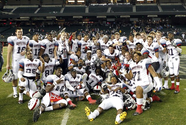 Members of the West All Americans pose with the Semper Fidelis All-American Bowl high school football game winners' trophy at Chase Field, Tuesday, Jan. 3, 2012, in Phoenix. West defeated East 17-14.  (AP Photo/Matt York)