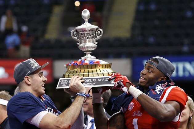 Mississippi quarterback Chad Kelly, left, and wide receiver Laquon Treadwell hold up the Sugar Bowl trophy after their victory over Oklahoma State in the Sugar Bowl college football game in New Orleans, Friday, Jan. 1, 2016. Mississippi won 48-20. (AP Photo/Jonathan Bachman)