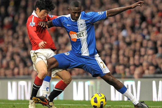 Manchester United's South Korean midfielder Park Ji-Sung (L) vies with Wigan Athletic's Ivorian defender Steve Gohouri during the English Premier League football match between Manchester United and Wigan Athletic at Old Trafford in Manchester, north-west England on November 20, 2010. AFP PHOTO/ANDREW YATES  FOR  EDITORIAL USE Additional licence required for any commercial/promotional use or use on TV or internet (except identical online version of newspaper) of Premier League/Football League photos. Tel DataCo +44 207 2981656. Do not alter/modify photo (Photo credit should read ANDREW YATES/AFP/Getty Images)