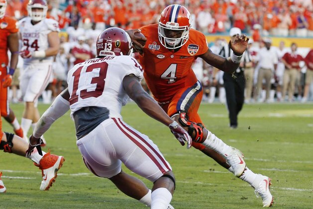 Clemson quarterback Deshaun Watson (4) attempts to evade Oklahoma safety Ahmad Thomas (13) on his way to a touchdown during the first half of the Orange Bowl NCAA college football semifinal playoff game, Thursday, Dec. 31, 2015, in Miami Gardens, Fla. (AP Photo/Joe Skipper)