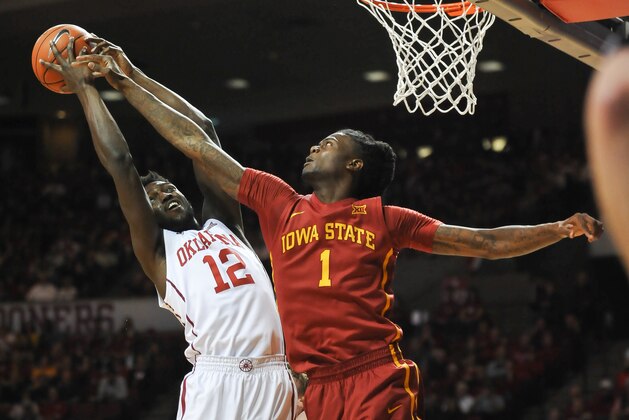 Oklahoma forward Khadeem Lattin (12) grabs a rebound over Iowa State forward Simeon Carter (1) during the first half of an NCAA college basketball game in Norman, Okla., Saturday, Jan. 2, 2016. (AP Photo/Kyle Phillips)
